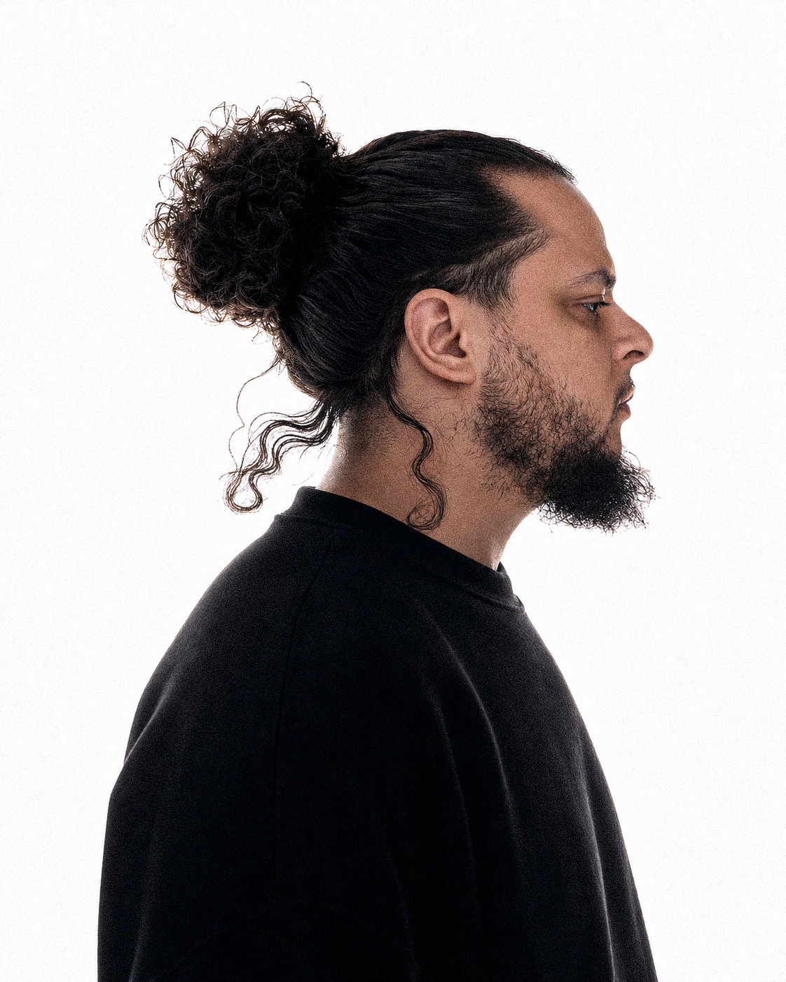 Fettah, El Florentino, in profile wearing a black shirt against a white background